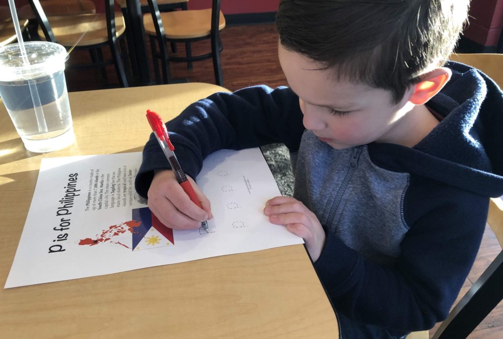 My son working on the Philippines worksheet from a preschool geography curriculum Letters Around the World at a Filipino restaurant - Exploring Through Life
