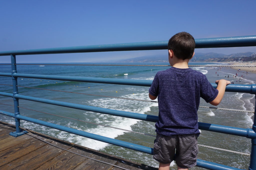 Child looking at the waves - Santa Monica Pier for Families - Exploring Through Life
