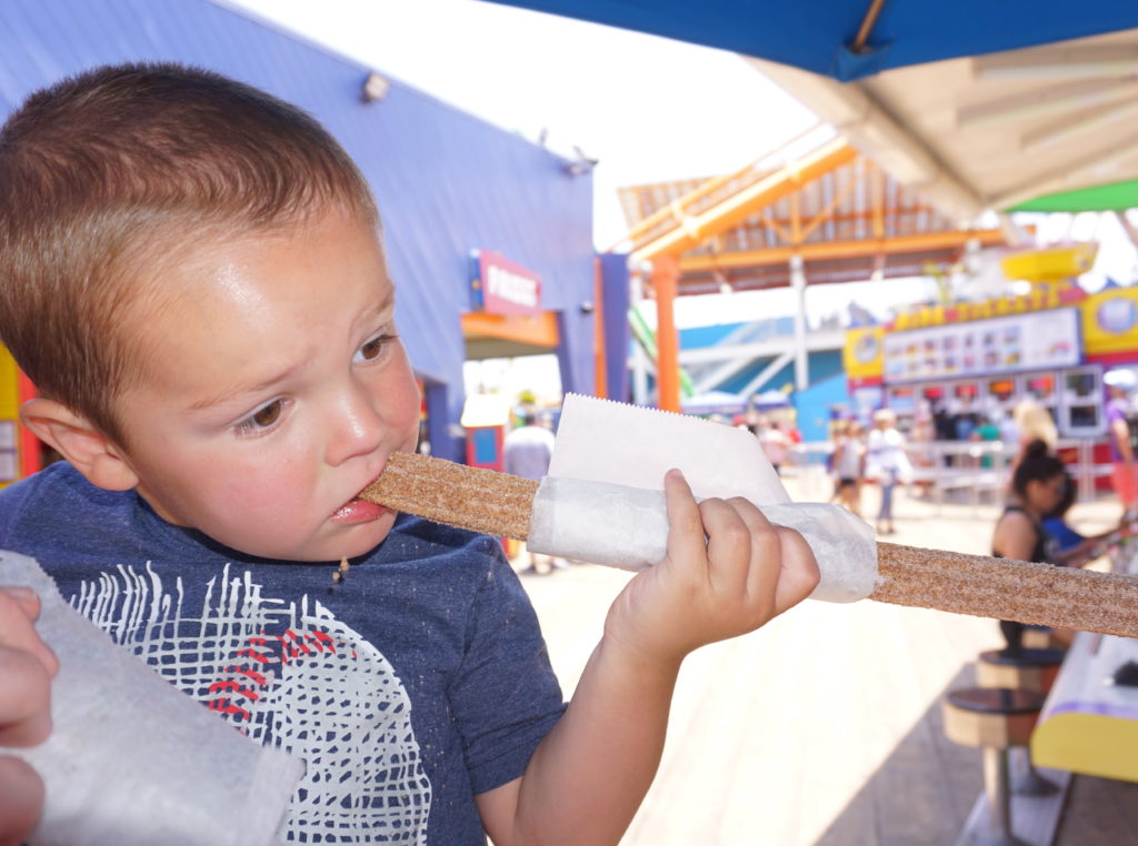 Boy eating churro - Santa Monica Pier for Families - Exploring Through Life