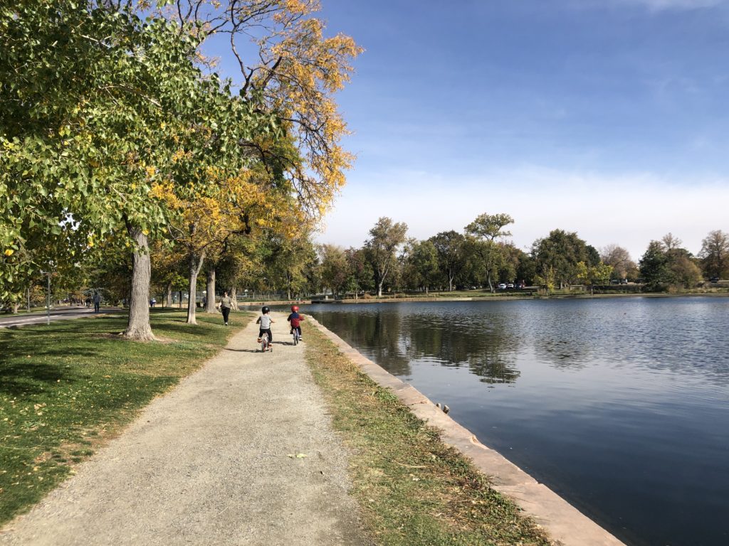 Washington Park in Denver is a great place for kids to play and explore. These kids love riding their bike around the lake. - Exploring Through Life
